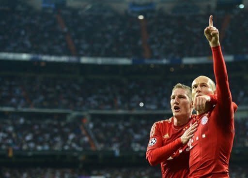 Bayern Munich's Dutch midfielder Arjen Robben (R) celebrates with Bayern Munich's midfielder Bastian Schweinsteiger after scoring from the penalty spot during the UEFA Champions League second leg semi-final football match Real Madrid against Bayern Munich at the Santiago Bernabeu stadium in Madrid. Bayern advanced to the final on penalties