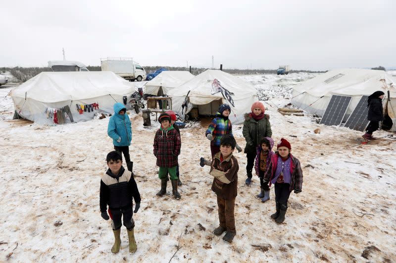 FILE PHOTO: Internally displaced children stand on snow near tents at a makeshift camp in Azaz