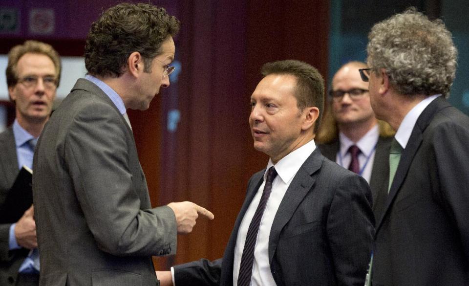 Greek Finance Minister Yannis Stournaras, third right, speaks with Dutch Finance Minister Jeroen Dijsselbloem, second left, during a meeting of the eurogroup at the EU Council building in Brussels on Monday, Feb. 17, 2014. Europe's economy is growing faster, raising hopes for a sustainable recovery, but that may not be enough to bring sky-high levels of unemployment down anytime soon. (AP Photo/Virginia Mayo)