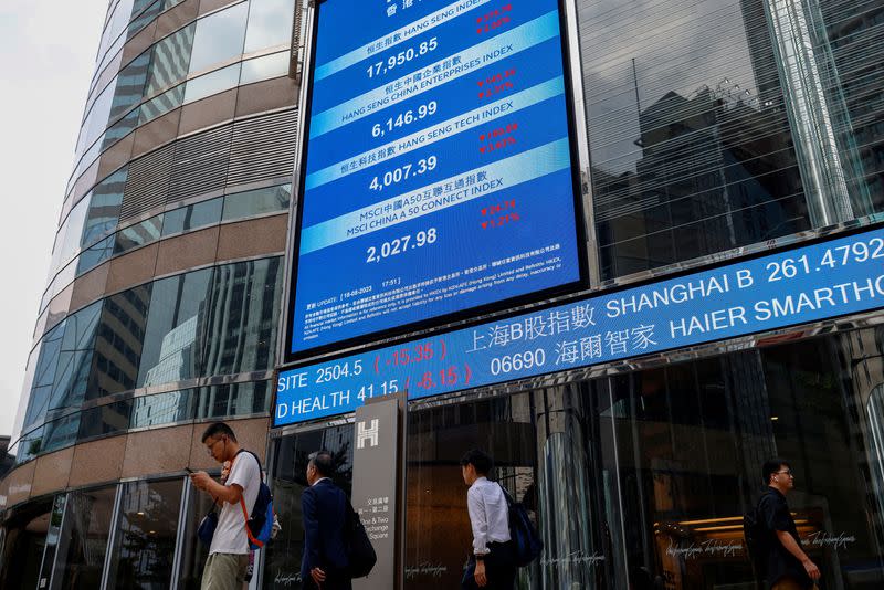 FILE PHOTO: Screens showing the Hang Seng stock index and stock prices are seen outside Exchange Square, in Hong Kong