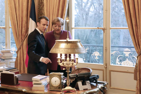 French President Emmanuel Macron (L) and German Chancellor Angela Merkel meet at the Eylsee presidential Palace in Paris, France March 16, 2018. Ludovic Marin/Pool via REUTERS