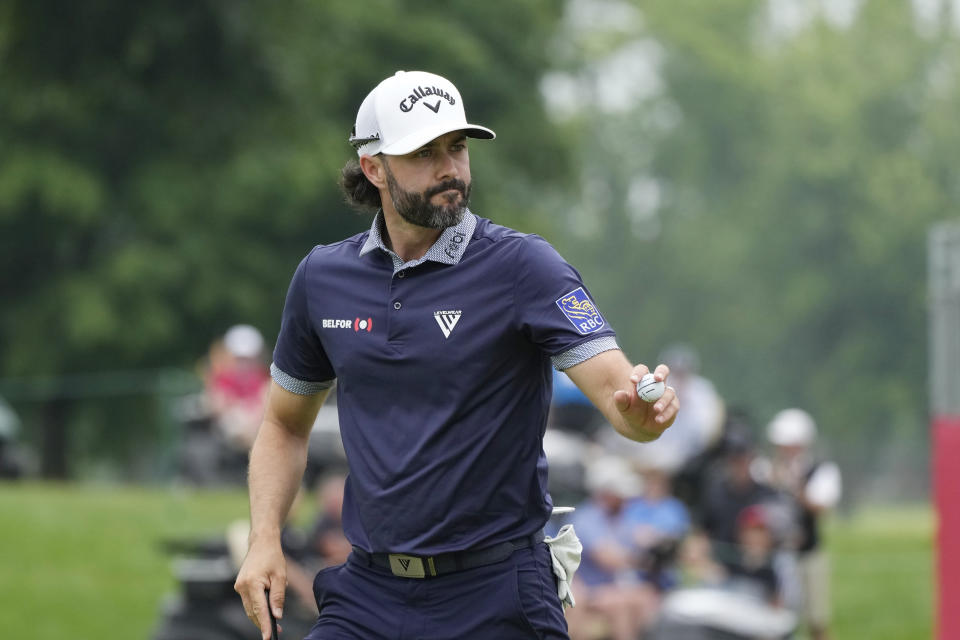 Adam Hadwin acknowledges the crowd after his par putt to tie Collin Morikawa and Rickie Fowler for a playoff during the final round of the Rocket Mortgage Classic golf tournament at Detroit Country Club, Sunday, July 2, 2023, in Detroit. (AP Photo/Carlos Osorio)