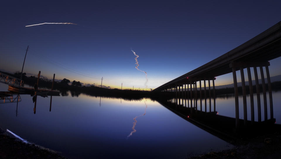 A United Launch Alliance Atlas V rocket streaks across the horizon at dawn in this view from the St. Johns River, east of Sanford, Fla., Friday, Dec. 20, 2019. The rocket was carrying Boeing's Starliner crew capsule toward the International Space Station on an unpiloted test flight and was visible along the U.S. east coast. (Joe Burbank/Orlando Sentinel via AP)