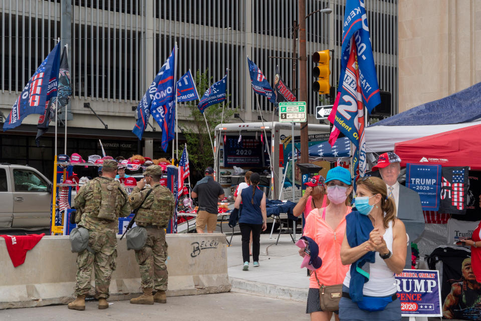 National Guard and vendors selling Trump memorabilia near an entrance to the Trump rally at the BOK Center in Tulsa, Okla., on June 20, 2020. | Peter van Agtmael—Magnum Photos for TIME