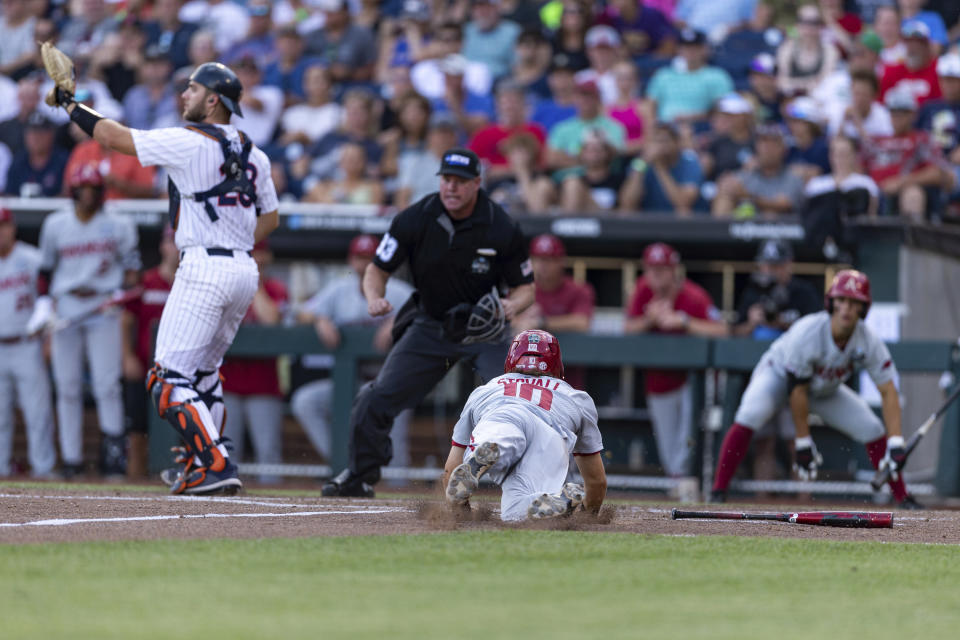 Arkansas infielder Peyton Stovall (10) slides home against Auburn catcher Nate LaRue (28) in the third inning during an NCAA College World Series baseball game Tuesday, June 21, 2022, in Omaha, Neb. (AP Photo/John Peterson)