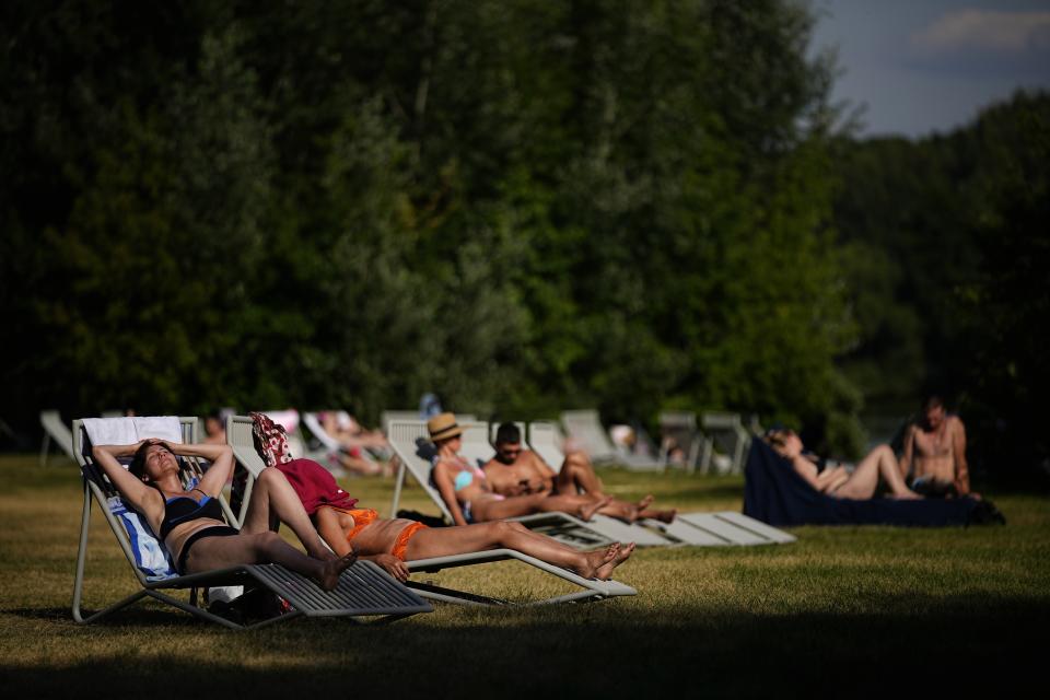 People enjoy the sun on a beach at Serebryany Bor park in Moscow, Russia, Thursday, July 11, 2024. (AP Photo/Pavel Bednyakov)