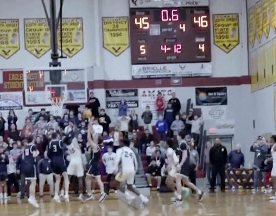 In this image taken from video provided by Joshua Clyburn, Manasquan's Griffin Linstra, center left, shoots as the clock winds down in the NJSIAA Group Tournament semifinal sound group 2 high school basketball game against Camden, Tuesday, March 5, 2024, in Berkley Township, N.J. Manasquan initially was declared the winner, however, the call was soon overturned when the referees discussed the shot and concluded it came after the buzzer, giving Camden a 46-45 win. (Joshua Clyburn via AP)