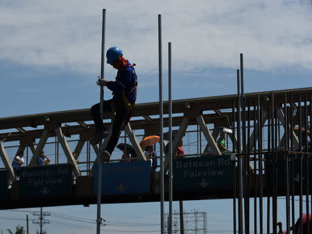 A worker assembles a pole at a construction site of the Metro Rail Transit (MRT) on Commonwealth Avenue in Quezon City, metro Manila, May 23, 2018. REUTERS/Dondi Tawatao