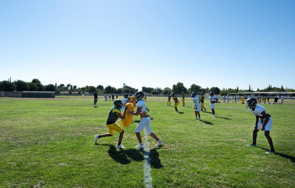 Davis High football players work on blocking during practice at Grace Davis High School in Modesto, Calif., Wednesday, August 9, 2023.