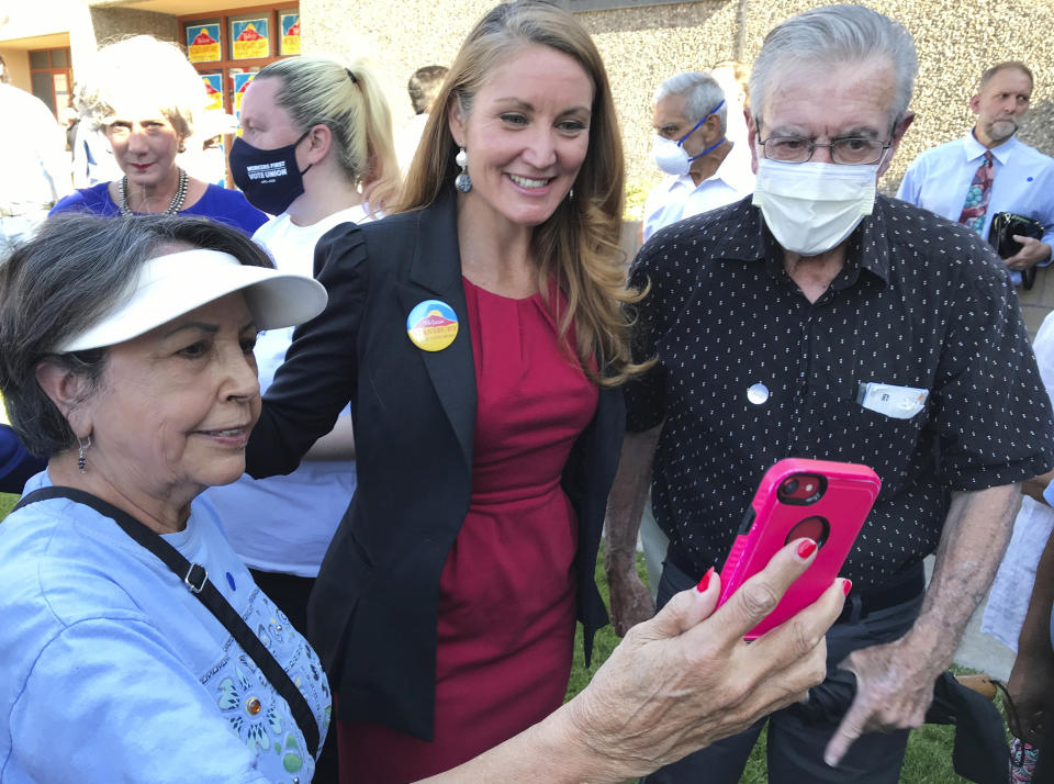 Democratic congressional candidate Melanie Stansbury, center, takes photos with supporters during a campaign rally in Albuquerque, New Mexico, on Thursday, May 27, 2021. She was joined by Doug Emhoff, the husband of Vice President Kamala Harris. The trip marked Emhoff's first on behalf of a candidate. (AP Photo/Susan Montoya Bryan)