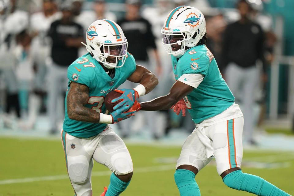 Miami Dolphins quarterback Teddy Bridgewater (5) hands the ball to running back Myles Gaskin (37) during the first half of a NFL preseason football game against the Las Vegas Raiders, Saturday, August 20, 2022, in Miami Gardens, Fla. (AP Photo/Wilfredo Lee)