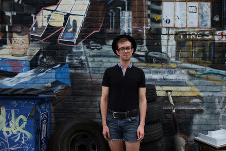 Seth Hatch, 24, an actor who works at a thrift shop in Williamsburg, poses for a picture in the Brooklyn borough of New York, U.S., September 2, 2018. REUTERS/Caitlin Ochs