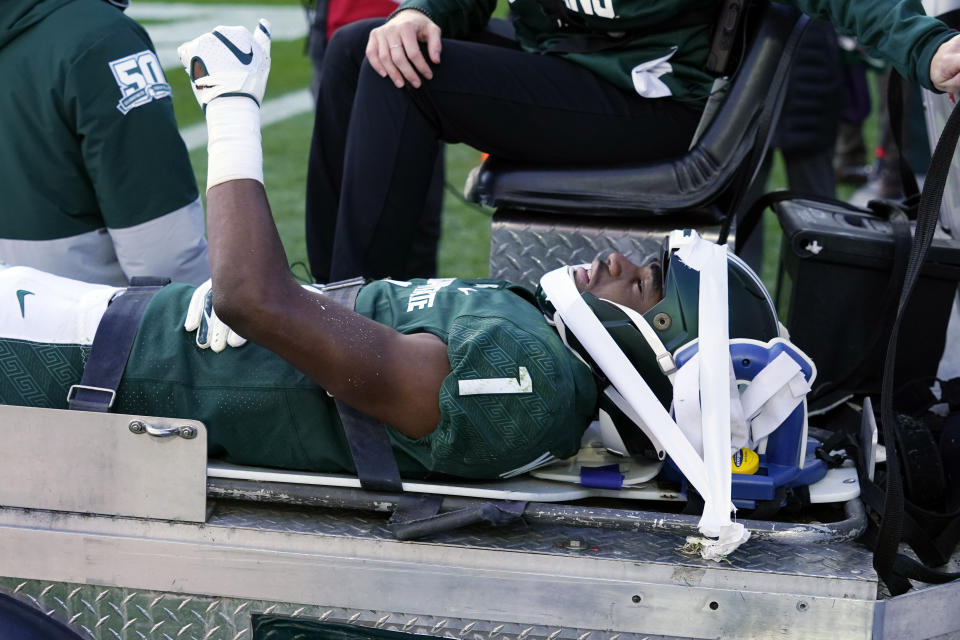 Michigan State safety Jaden Mangham gives a thumbs up as he is carted off the field during the first half of an NCAA college football game against Ohio State, Saturday, Oct. 8, 2022, in East Lansing, Mich. (AP Photo/Carlos Osorio)