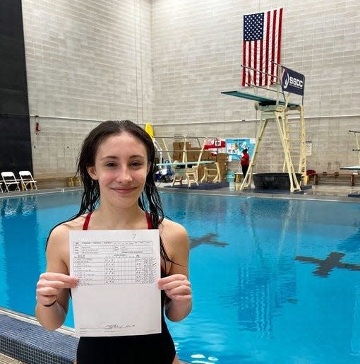 Durfee diver Madison Ferreira holds up her score sheet after finishing with a state championship qualifying score of 202.50.