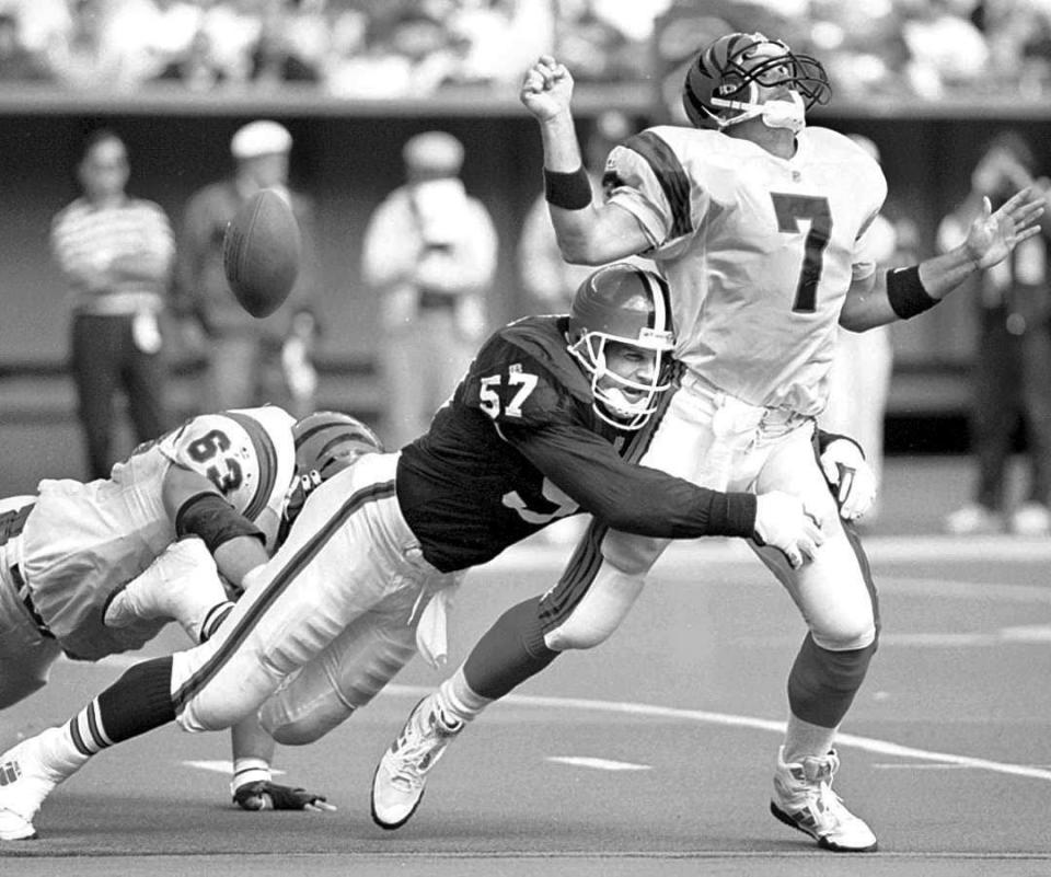 Cincinnati Bengals quarterback David Klingler fumbles the football as he is sacked by Cleveland Browns linebacker Clay Matthews during the second quarter in Cincinnati Sunday, Oct. 17, 1993. Klingler left the game on the play. Bengals offensive lineman Joe Walter attempts to block Matthews.