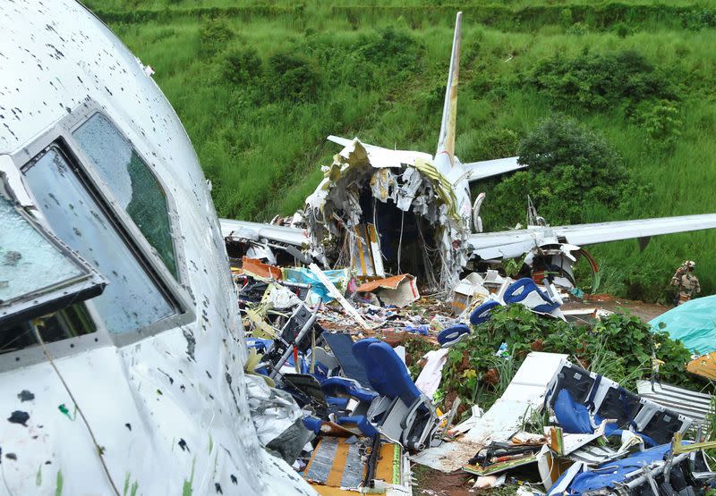 Un agente de seguridad inspecciona el lugar donde se estrelló un avión de pasajeros al salirse de la pista del Aeropuerto Internacional de Calicut en Karipur