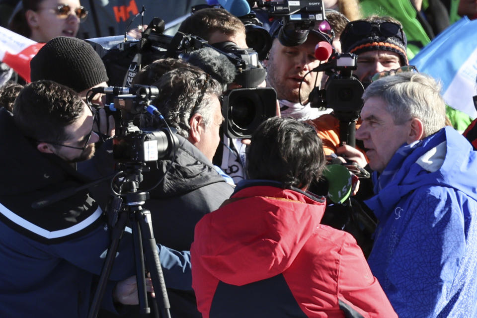 IOC (International Olympic Committee) President Thomas Bach, right, meets the media in the finish area of the alpine ski, men's World Championship downhill, in Courchevel, France, Sunday, Feb. 12, 2023. (AP Photo/Marco Trovati)