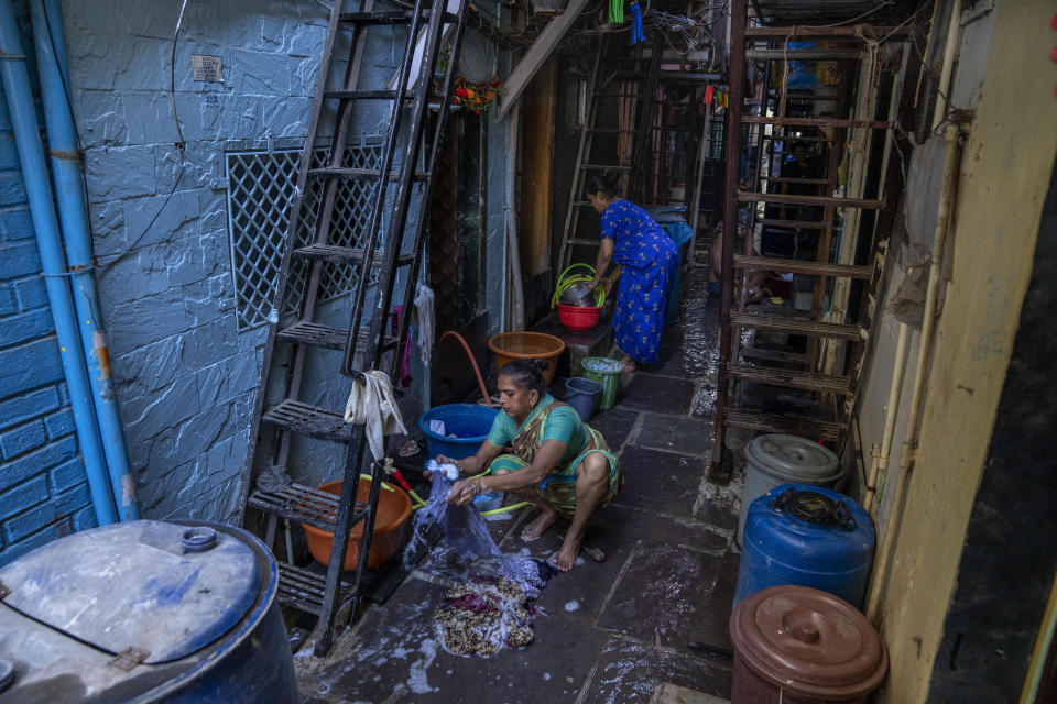 Women wash clothes outside their dwellings in Dharavi, one of Asia's largest slums, in Mumbai, India, Wednesday, May 3, 2023. The Indian government has promised that every legal household will soon have plumbing and running water - a goal set for this year that has yet to be reached. For now, people in this neighborhood must get their water from outside spigots from 6 to 9 a.m. most days. (AP Photo/Dar Yasin)