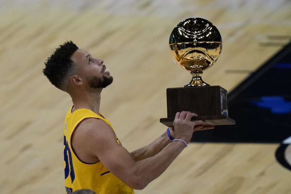 Golden State Warriors guard Stephen Curry holds the trophy after winning the 3-point contest at basketball's NBA All-Star Game in Atlanta, Sunday, March 7, 2021. (AP Photo/Brynn Anderson)