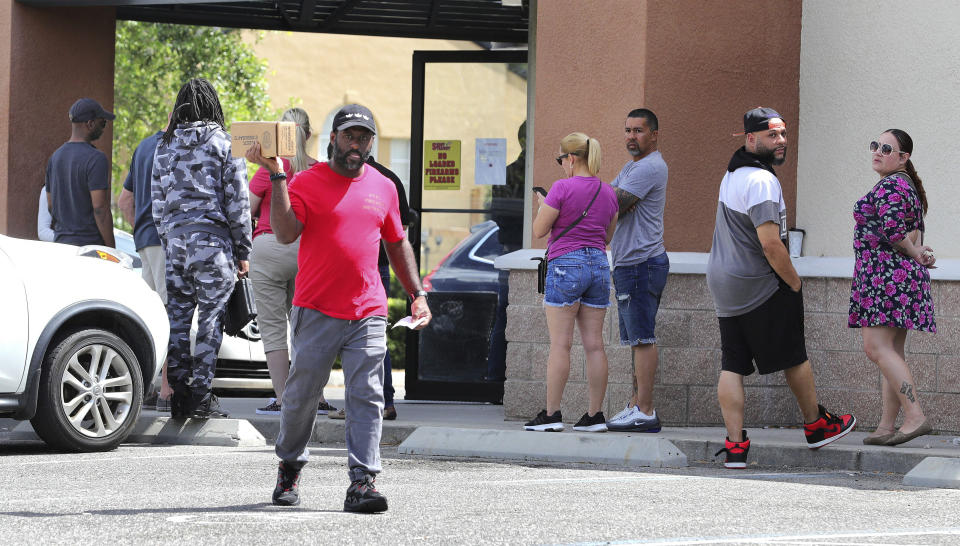 A gun owner leaves the Shoot Straight gun store in Casselberry, Fla., Sunday, March 22, 2020. Gun sales have increased nationwide in response to the coronavirus pandemic. (Joe Burbank/Orlando Sentinel via AP)