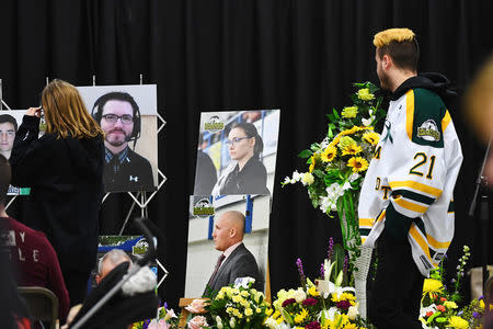 Humboldt Broncos' Nick Shumlanski, who was released from hospital earlier today, looks at photographs of other victims during a vigil at the Elgar Petersen Arena, home of the Humboldt Broncos, to honour the victims of a fatal bus accident in Humboldt, Saskatchewan, Canada April 8, 2018. Jonathan Hayward/Pool via REUTERS