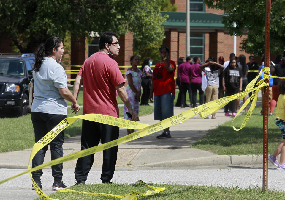 People gather outside of Heritage High School following a shooting, Monday, Sept. 20, 2021, in Newport News, Va. (Kaitlin McKeown/The Virginian-Pilot via AP)