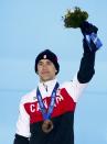 Bronze medallist Denny Morrison of Canada waves during the victory ceremony for the men's 1,500 metres speed skating event at the Sochi 2014 Winter Olympic Games in Sochi February 16, 2014. REUTERS/Eric Gaillard (RUSSIA - Tags: OLYMPICS SPORT SPEED SKATING)