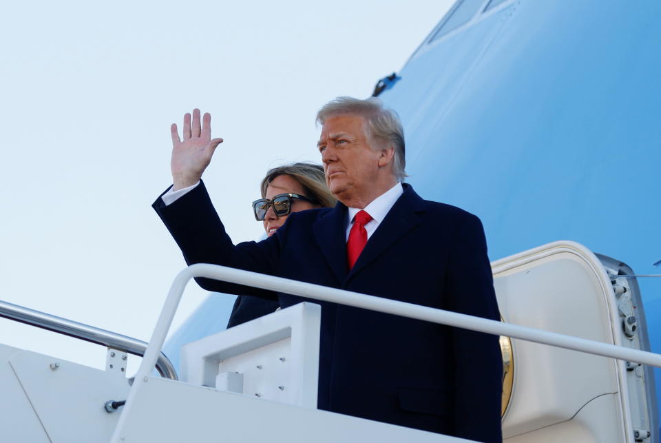 U.S. President Donald Trump, accompanied by first lady Melania Trump, waves as he boards Air Force One at Joint Base Andrews, Maryland, U.S., January 20, 2021. REUTERS/Carlos Barria