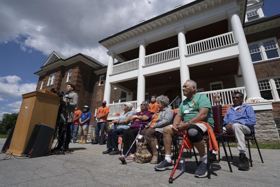 Survivors of the Mohawk Institute, with Six Nations Elected Chief Mark B. Hill at the podium, at a press conference in July 2021, requested a criminal investigation into, and a search for, unmarked graves on the grounds. THE CANADIAN PRESS/Peter Power