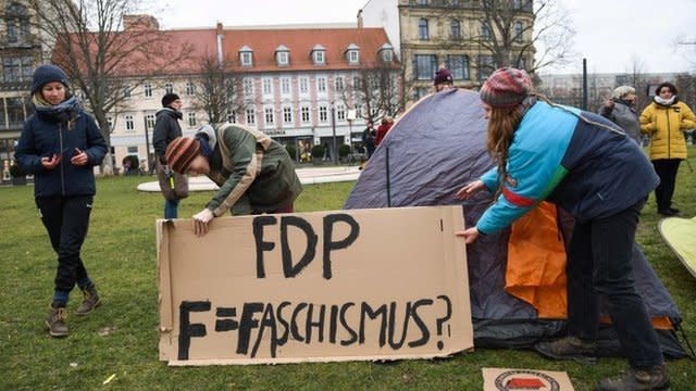 Manifestantes con un cartel en el que atacan al FDP.