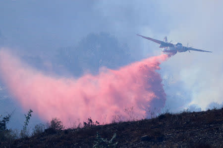 Water bombers drop fire retardant as they work to protect a Sullivan Middle School from a fast moving wild fire in Bonsall, California, U.S., December 7, 2017. REUTERS/Mike Blake