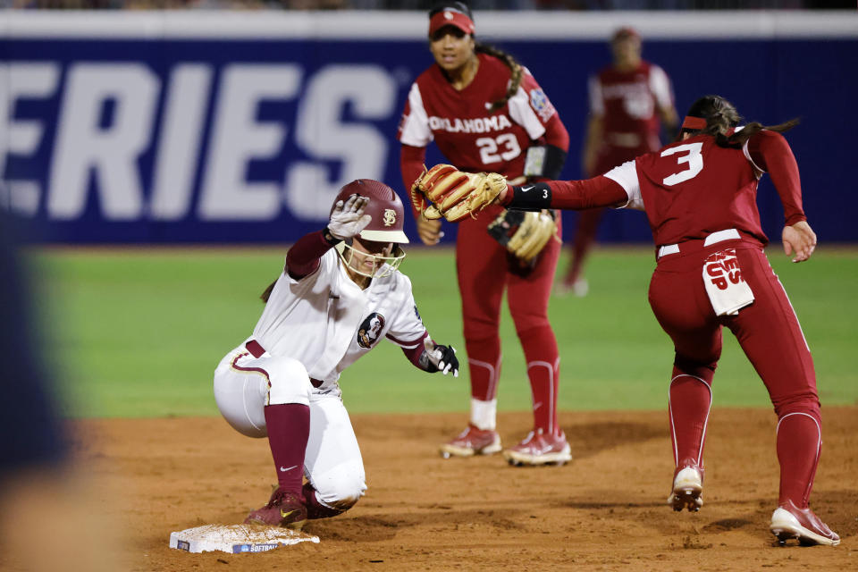 Florida State's Hallie Wacaser, left, steals second base past Oklahoma's Grace Lyons (3) during the third inning of the first game of the NCAA Women's College World Series softball championship series Wednesday, June 7, 2023, in Oklahoma City. (AP Photo/Nate Billings)