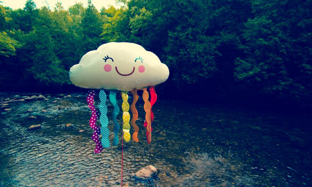 Cloudhelium balloon with face standing on river