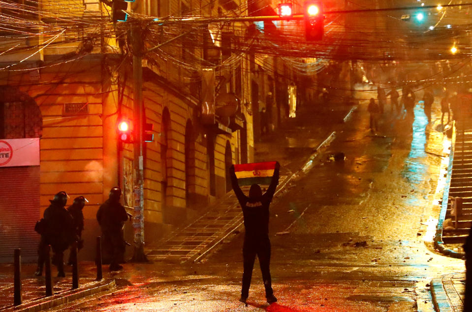 A demonstrator holds up a Bolivian flag during clashes between protesters against Bolivia's President Evo Morales and government supporters, in La Paz, Bolivia Nov. 7, 2019. (Photo: Kai Pfaffenbach/Reuters)