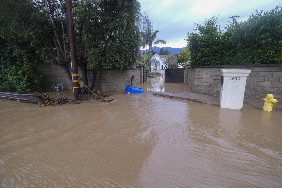 FILE - A driveway is flooded by the overflowing San Ysidro creek on Jameson Lane in Montecito, Calif., on Jan. 10, 2023. California Gov. Gavin Newsom has proposed cutting $40 million from the state budget for floodplain projects to help balance the state budget. The Newsom administration says the projects could be funded from other places in the budget. But advocates say the decision will lead to significant delays if it stands. (AP Photo/Ringo H.W. Chiu, File)