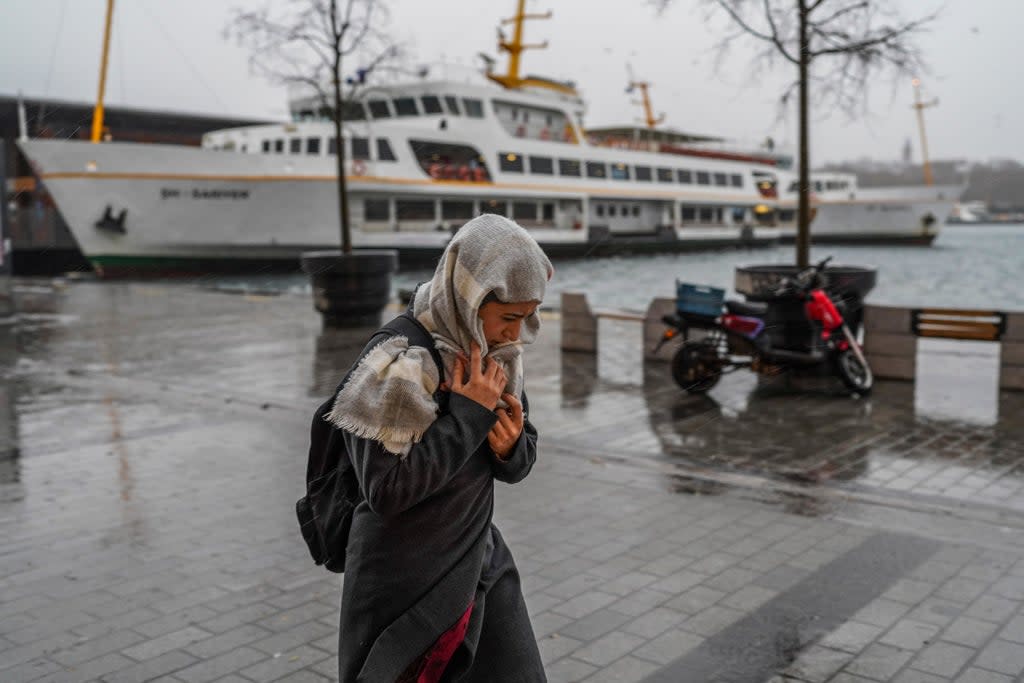 A woman walks under a heavy rain in Istanbul (AP)