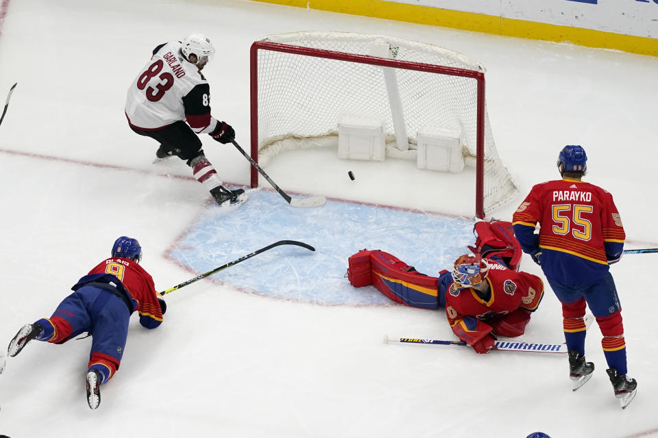 Arizona Coyotes' Conor Garland (83) scores past St. Louis Blues' Sammy Blais (9), goaltender Jordan Binnington (50) and Colton Parayko (55) during the second period of an NHL hockey game Thursday, Feb. 4, 2021, in St. Louis. (AP Photo/Jeff Roberson)