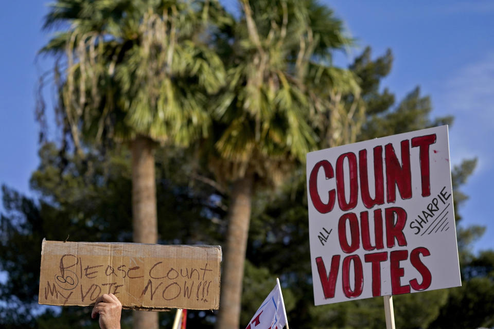 Protesters hold signs during an Arizona Republican Party news conference, Thursday, Nov. 5, 2020, in Phoenix. (AP Photo/Matt York)