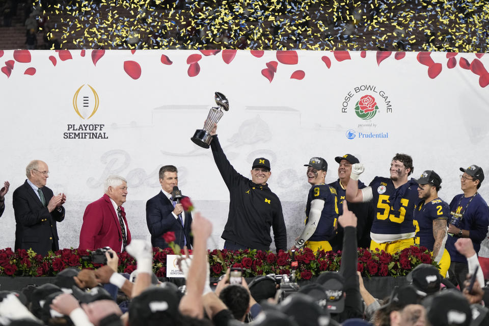 Michigan head coach Jim Harbaugh holds the winner's trophy after a win over Alabama in the Rose Bowl CFP NCAA semifinal college football game Monday, Jan. 1, 2024, in Pasadena, Calif. (AP Photo/Mark J. Terrill)