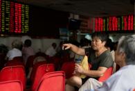 Investors monitor screens showing stock market movements at a brokerage house in Shanghai on August 13, 2015
