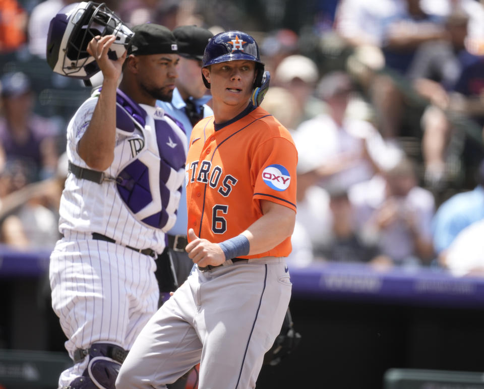 Houston Astros' Jake Meyers, front, scores on a single hit by Mauricio Dubon as Colorado Rockies catcher Elias Diaz (35) looks on in the third inning of a baseball game Wednesday, July 19, 2023, in Denver. (AP Photo/David Zalubowski)