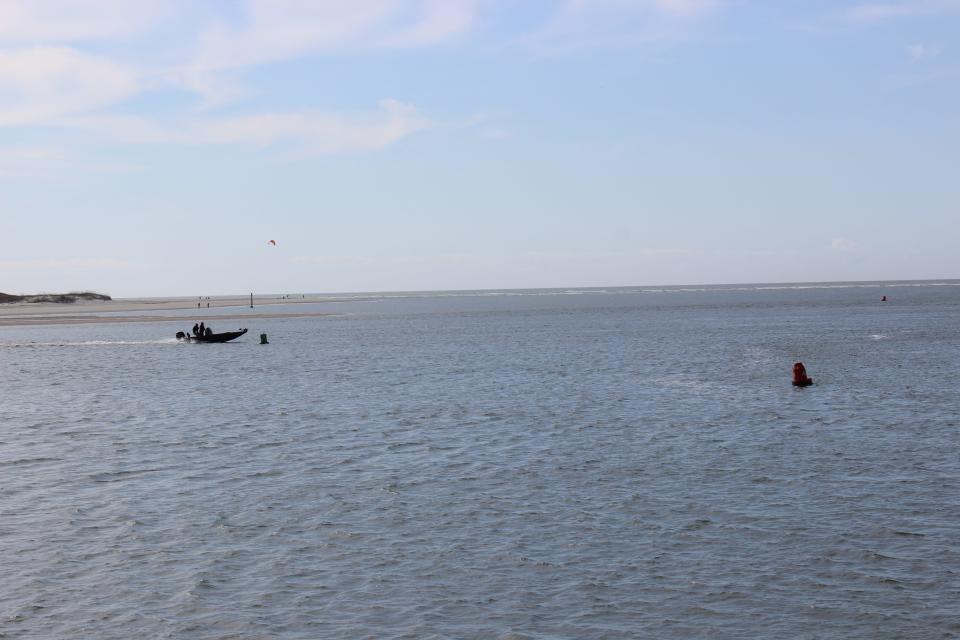 A small boat cruises past the west end of Oak Island on Friday, March 17, 2023.