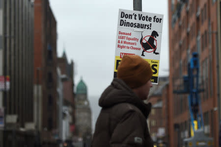 A man walks past an electionl poster saying 'Don't vote for Dinosaurs!' in Belfast, Northern Ireland February 6, 2017. REUTERS/Clodagh Kilcoyne