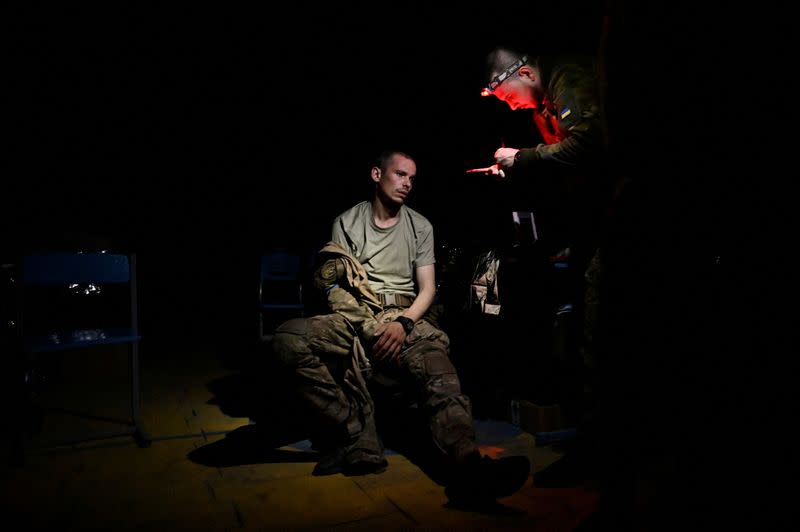 FILE PHOTO: A medic speaks with an injured Ukrainian serviceman inside a frontline medical stabilisation point in Zaporizhzhia region