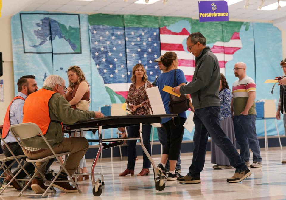 People line up to vote in front of a mural at a Elementary school polling station Tuesday Nov. 7, 2023, in Midlothian, Va. (AP Photo/Steve Helber)