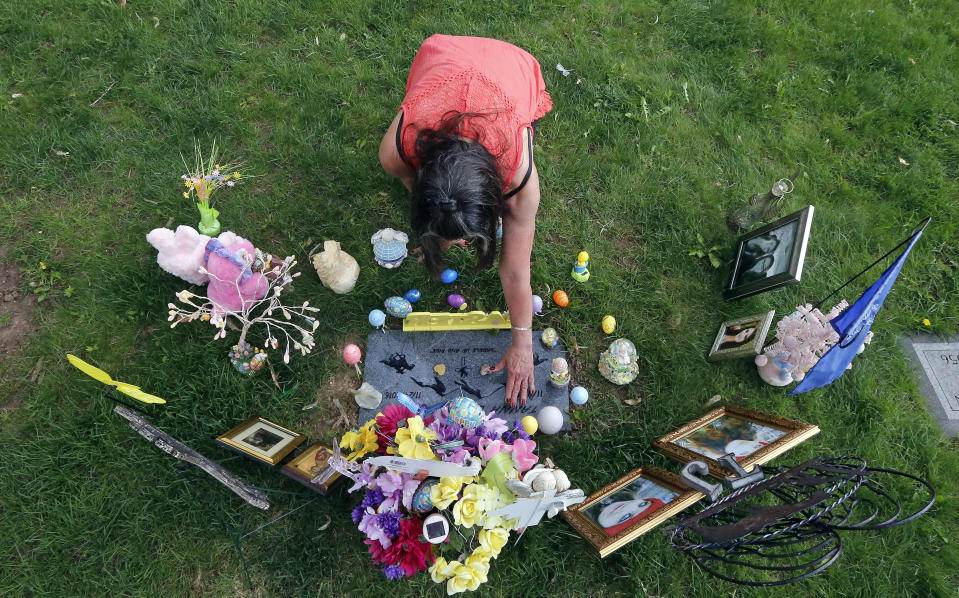 Melany Zoumadakis arranges photos and flowers that she brought to the grave of her daughter, Tanna Jo Fillmore, on April 26, 2019, in Salt Lake City. Fillmore killed herself in 2016 while being held on a probation violation. She had threatened to harm herself after she told her mother she was being denied her prescription medicines. Her mother has filed suit. (AP Photo/Rick Bowmer)