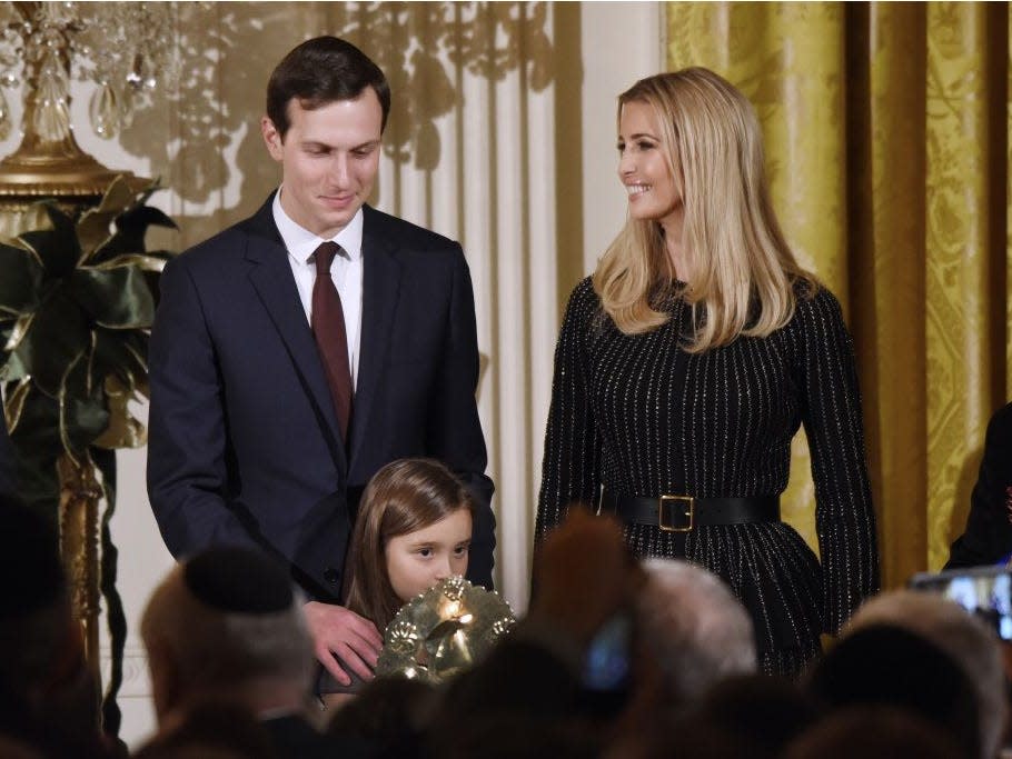 Arabella Kushner lights the menorah as Jared Kushner and Ivanka Trump look on during a Hanukkah reception in the East Room of the White House in 2017.