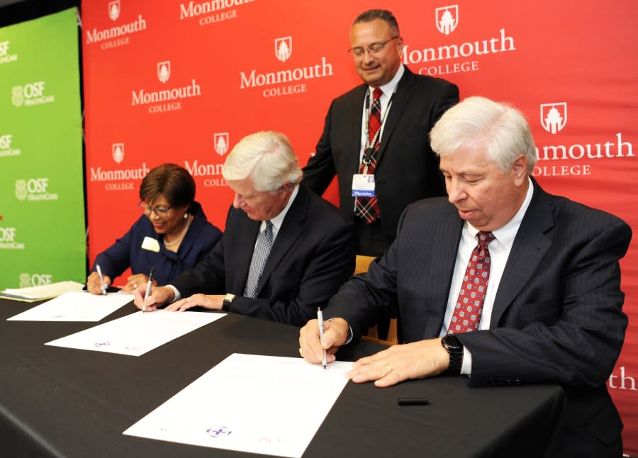 Monmouth College and OSF HealthCare officials sign a letter of commitment May 9 at Monmouth College to bring a 3+1 nursing program to campus. From left: Saint Francis Medical Center College of Nursing President Charlene Aaron, Monmouth President Clarence Wyatt and OSF HealthCare Chief Executive Officer Bob Sehring. Looking on is OSF HealthCare System Chief Medical Officer and Monmouth Board of Trustees Vice Chair Dr. Ralph Velazquez Jr. ’79. (Monmouth College)