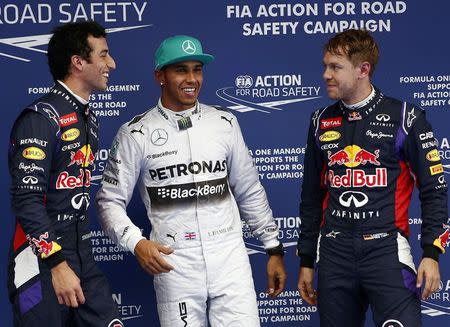 Mercedes Formula One driver Lewis Hamilton (C) of Britain celebrates with second-fastest Red Bull Formula One driver Daniel Ricciardo (L) of Australia and Ricciardo's team-mate, third-fastest Sebastian Vettel of Germany, after taking pole position at the qualifying session of the Chinese F1 Grand Prix at the Shanghai International circuit, April 19, 2014. REUTERS/Aly Song