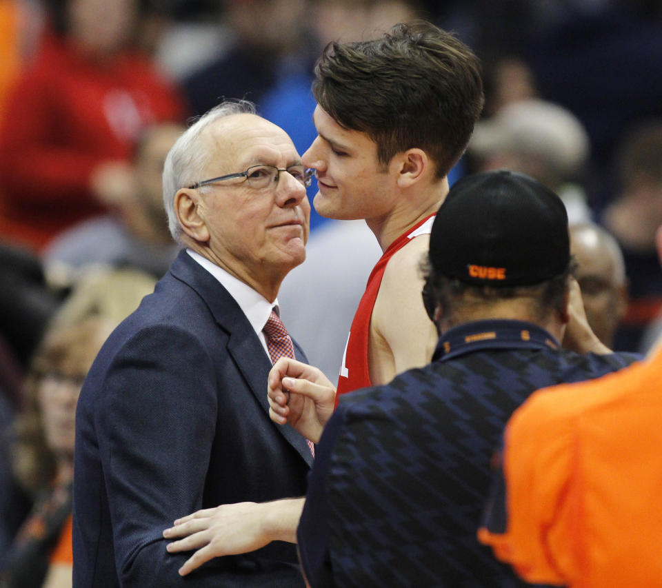 FILE - Syracuse head coach Jim Boeheim, left, congratulates his son, Cornell's Jimmy Boeheim, right, at the end of an NCAA college basketball game in Syracuse, N.Y., in this Friday, Nov. 10, 2017, file photo. Jimmy Boeheim is transferring to Syracuse to play for his father and with his younger brother after three seasons at Cornell. Coach Jim Boeheim's oldest son made the announcement Friday, April 16, 2021, on Instagram. (AP Photo/Nick Lisi, File)